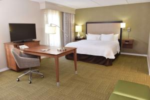 アレクサンドリアにあるHampton Inn & Suites Alexandriaのベッド、デスク、コンピュータが備わるホテルルームです。
