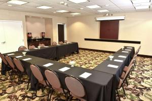 a conference room with tables and chairs and a podium at Hampton Inn & Suites Alexandria in Alexandria
