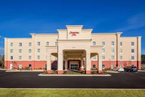 奥古斯塔Hampton Inn Augusta Fort Eisenhower的一座大型的白色建筑,与酒店同在