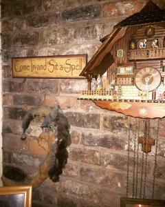 eine Wand mit einer Uhr an einer Ziegelmauer in der Unterkunft Bumbleberry Cottage in Gresford