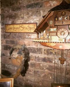 un mur avec une horloge sur un mur de briques dans l'établissement Bumbleberry Cottage, à Gresford