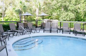 uma piscina com cadeiras e uma fonte em Hampton Inn Amelia Island em Fernandina Beach