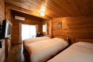 a room with three beds in a wooden cabin at Log house Grazzi - Vacation STAY 70263v in Nasu-yumoto