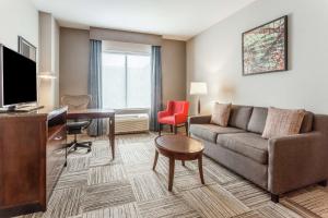 a living room with a couch and a desk at Hilton Garden Inn Albany-SUNY Area in Albany