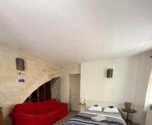 een slaapkamer met een rood bed en een rode bank bij Appart' Cosy Beaucairois in Beaucaire