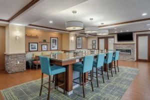 a large kitchen with a bar with blue chairs at Hampton Inn Alamosa in Alamosa