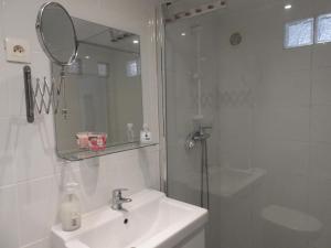 een badkamer met een wastafel en een douche met een spiegel bij Appart' Cosy Beaucairois in Beaucaire