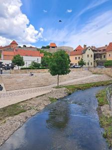 a river in a city with buildings in the background at BB21 Apartman Eger - City centre in Eger