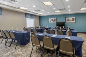 una sala de conferencias con mesas y sillas azules y un podio en Hampton Inn Alamosa, en Alamosa