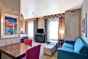 アマリロにあるHomewood Suites by Hilton Amarilloのリビングルーム(テーブル、椅子、ソファ付)