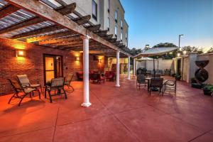 a patio with chairs and tables and a brick building at Hampton Inn Jacksonville in Jacksonville