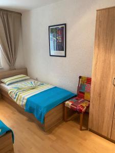 ein kleines Schlafzimmer mit einem Bett und einem Stuhl in der Unterkunft Apartment Maki with new Pool Nin in Vrsi + 81 Fotos