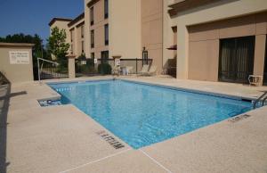 a swimming pool in front of a building at Hampton Inn Americus in Americus