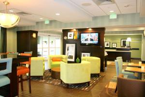 un restaurante con sillas, mesas y TV en Hampton Inn Anderson/Alliance Business Park, en Anderson