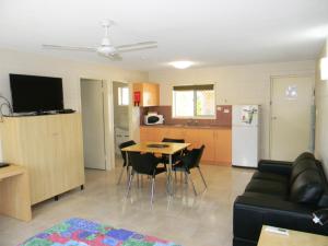 sala de estar y cocina con mesa y sofá en Rover Motel, en Mackay