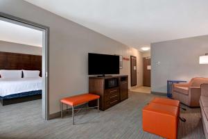 a hotel room with a bed and a flat screen tv at Hampton Inn Anderson in Anderson