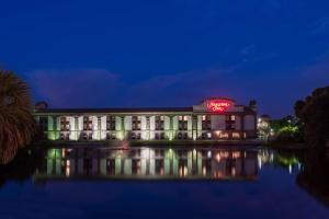 a building with a neon sign on it at night at Hampton Inn Bonita Springs Naples North in Bonita Springs