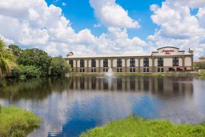 a large building with a lake in front of it at Hampton Inn Bonita Springs Naples North in Bonita Springs