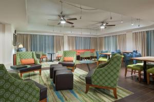 a living room with chairs and tables and chairs at Hampton Inn Bonita Springs Naples North in Bonita Springs