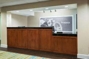 a lobby with a reception desk and a sign that says happy at Hampton Inn Bonita Springs Naples North in Bonita Springs