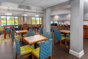 a restaurant with tables and chairs and a bar at Hampton Inn Bonita Springs Naples North in Bonita Springs