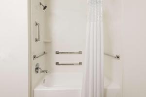 a bathroom with a shower with a white shower curtain at Hampton Inn Bonita Springs Naples North in Bonita Springs
