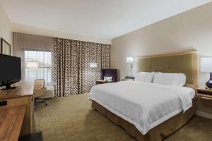a hotel room with a bed and a flat screen tv at Hampton Inn Bonita Springs Naples North in Bonita Springs