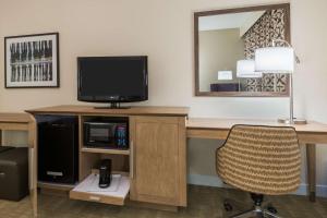 a hotel room with a desk with a television and a chair at Hampton Inn Bonita Springs Naples North in Bonita Springs