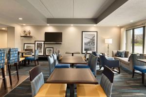 una sala d'attesa con tavoli, sedie e un divano di Hampton Inn Appleton-Fox River Mall Area ad Appleton