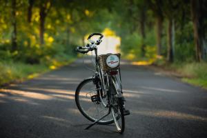 ein Fahrrad, das auf einer Straße geparkt ist, mit einem Korb in der Unterkunft Drents Genieten - Riegheide met privé jacuzzi in Erm