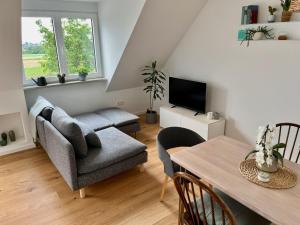 a living room with a couch and a table at Tolle Maisonette Wohnung mit Seeblick - Ferienwohnung Seeliebe in Büchelberg +7 photos