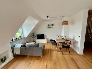 a living room with a couch and a table at Tolle Maisonette Wohnung mit Seeblick - Ferienwohnung Seeliebe in Büchelberg