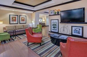 uma sala de estar com uma grande televisão de ecrã plano em Hampton Inn Covington em Covington
