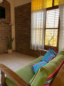 sala de estar con sofá verde y ventana en Departamento Privado para dos personas en Mendoza en Godoy Cruz