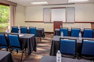 una sala de conferencias con mesas, sillas y una pantalla en Hampton Inn & Suites Atlanta/Duluth/Gwinnett en Duluth