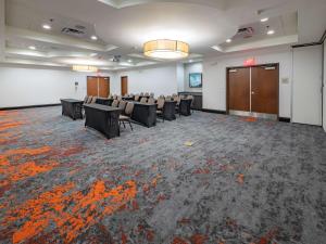 una sala de conferencias con sillas, un podio y una puerta en Hilton Garden Inn Atlanta South-McDonough, en McDonough