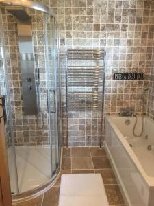 ein Badezimmer mit einer Dusche, einer Badewanne und einem Waschbecken in der Unterkunft Bumbleberry Cottage in Gresford