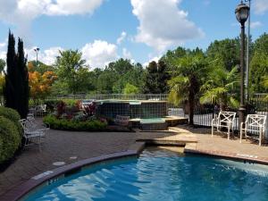una piscina en un patio con sillas y árboles en Hampton Inn & Suites Atlanta-Six Flags en Lithia Springs