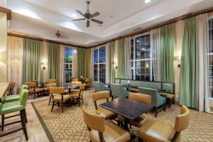 un restaurante con mesas, sillas y ventanas en Hampton Inn & Suites-Austin Airport, en Austin