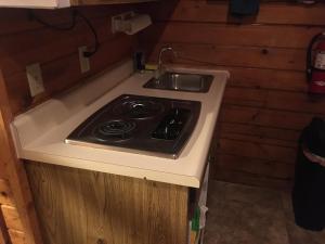 uma cozinha com um fogão e um lavatório em Cabin 1. For freedom loving simple not picky people. Rental cars available. em Custer