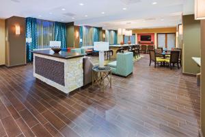 a hotel lobby with a bar and tables and chairs at Hampton Inn Austin Oak Hill in Austin