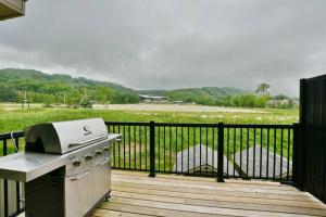 a grill on a deck with a view of a field at Quaint Mountainside Splendor in Blue Mountains