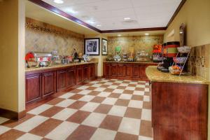 een grote keuken met houten kasten en een geruite vloer bij Hampton Inn & Suites Altus in Altus