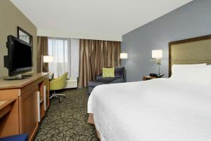 a hotel room with a bed and a flat screen tv at Hampton by Hilton Austin South - I-35 & Ben White in Austin