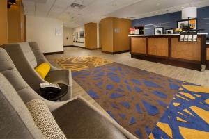 Hampton Inn & Suites Baltimore/Woodlawn في بالتيمور: غرفة انتظار مع كنب ومطبخ