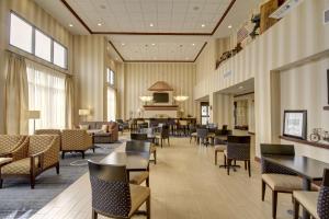 a restaurant with tables and chairs in a lobby at Hampton Inn and Suites Alexandria in Alexandria