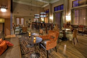 um átrio com mesas e cadeiras e um bar em Hampton Inn & Suites Kalamazoo-Oshtemo em Oshtemo