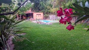 un patio con piscina y una flor rosa en Casa Darragueira en Chacras de Coria
