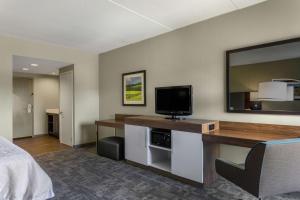 a hotel room with a bed and a flat screen tv at Hampton Inn Bedford in Bedford