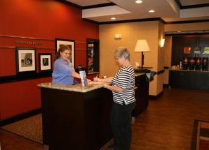 dos mujeres de pie en un bar en una habitación de hotel en Hampton Inn & Suites Buffalo, en Buffalo